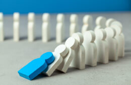 Domino effect in business. One businessman leader falls and brings down other figures of employees. System disruption